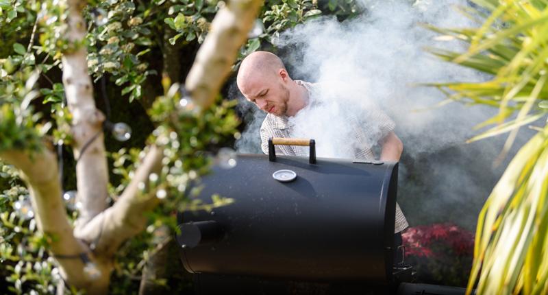 Mann nutzt Pellet Smoker
